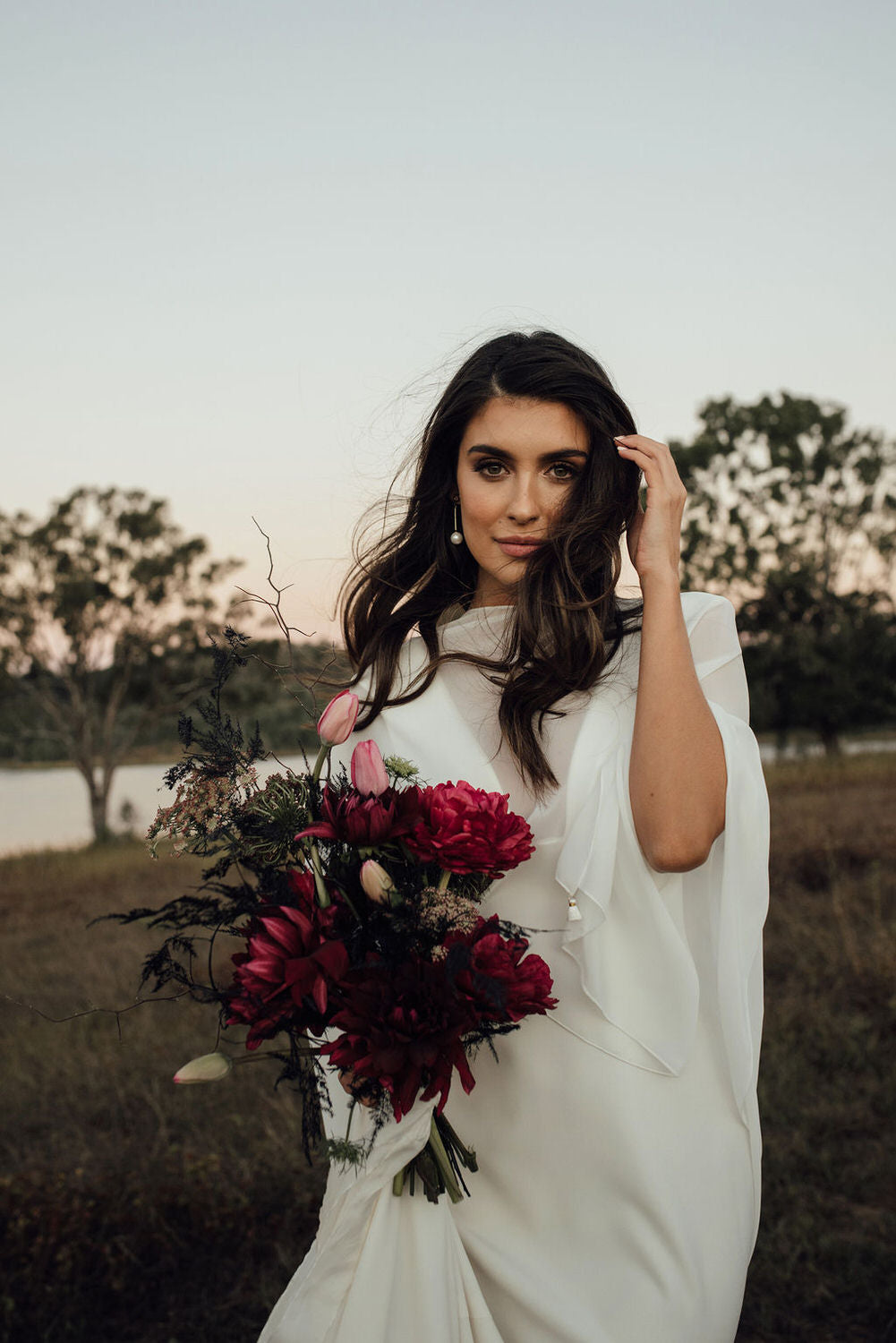 Modern bride wearing gold pearl drop earrings by Amélie George Bridal at a Scenic Rim wedding editorial at The Overflow Estate 1895, styled with a minimalist Karen Willis Holmes silk gown.