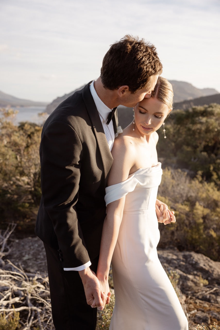 Bride wearing IMOGEN long pearl bridal earrings and chapel-length wedding veil by Amélie George Bridal, styled with a Frahn Bridal gown on Tasmania's Freycinet coast, captured by Heart and Colour Photography.