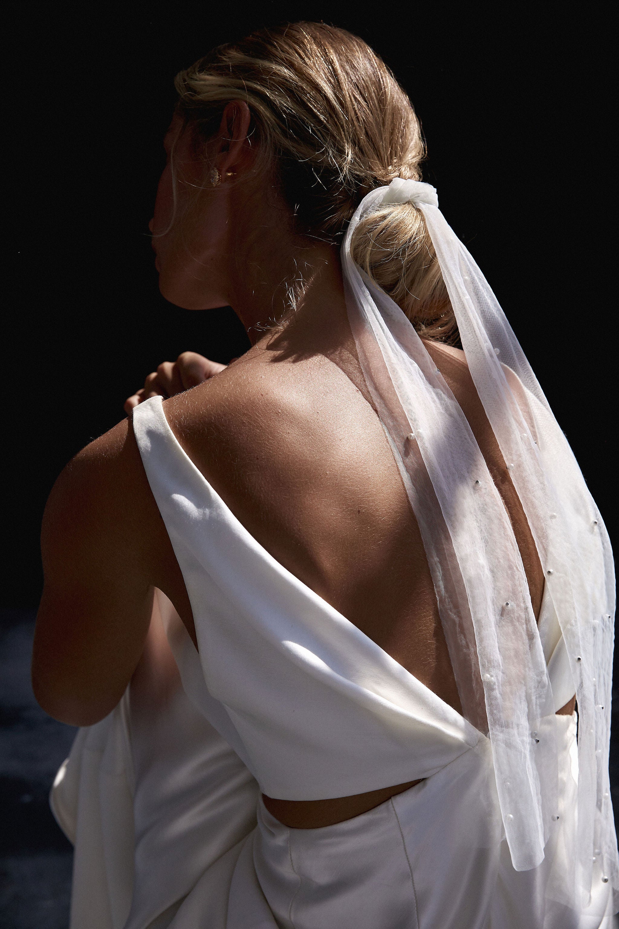 Bridal hairstyle adorned with a beautiful tulle wedding veil tie, offering a modern alternative to traditional veils.