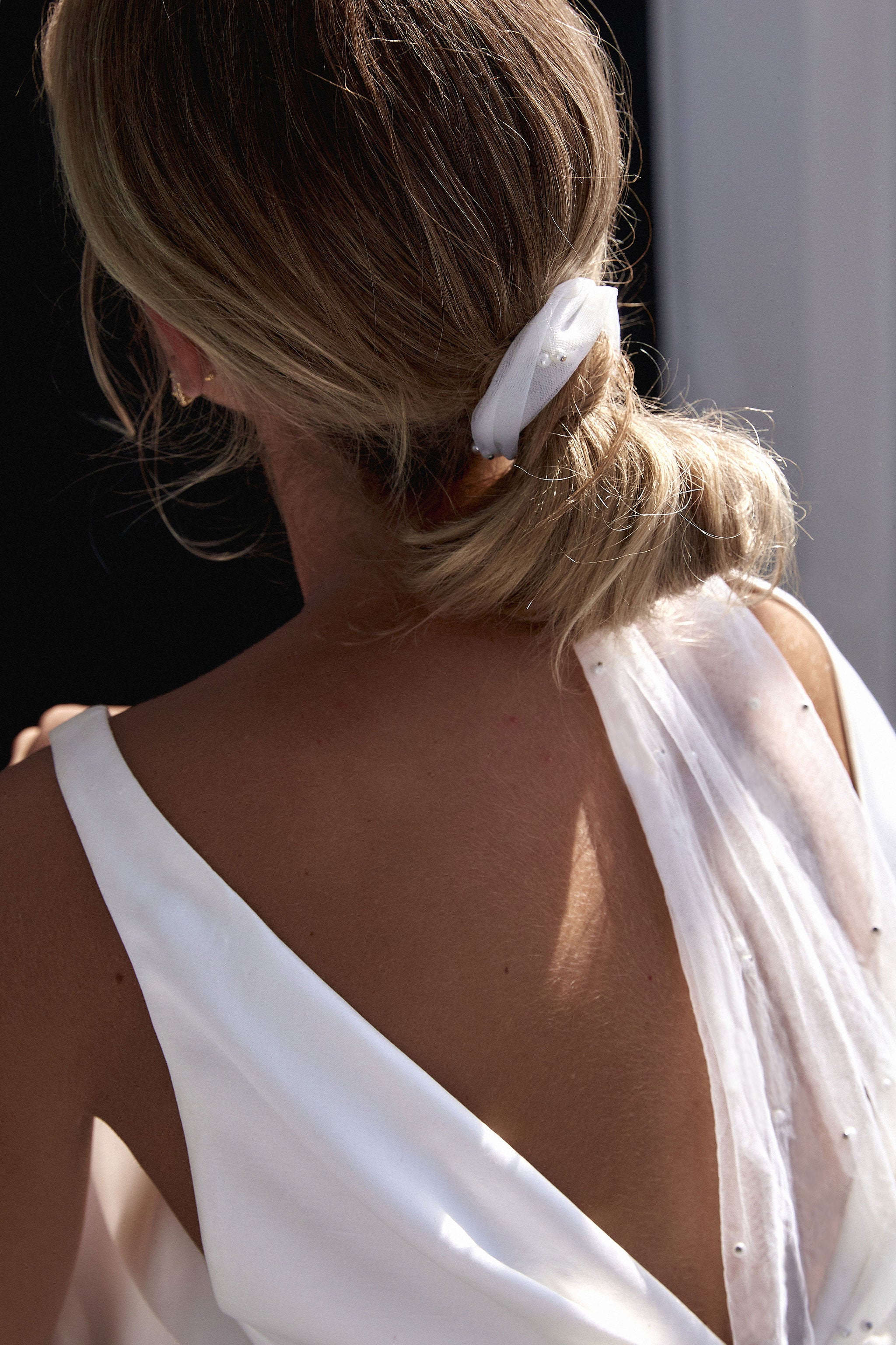 Modern bride wearing a delicate bow veil, enhancing her bridal hairstyle with minimalist elegance.