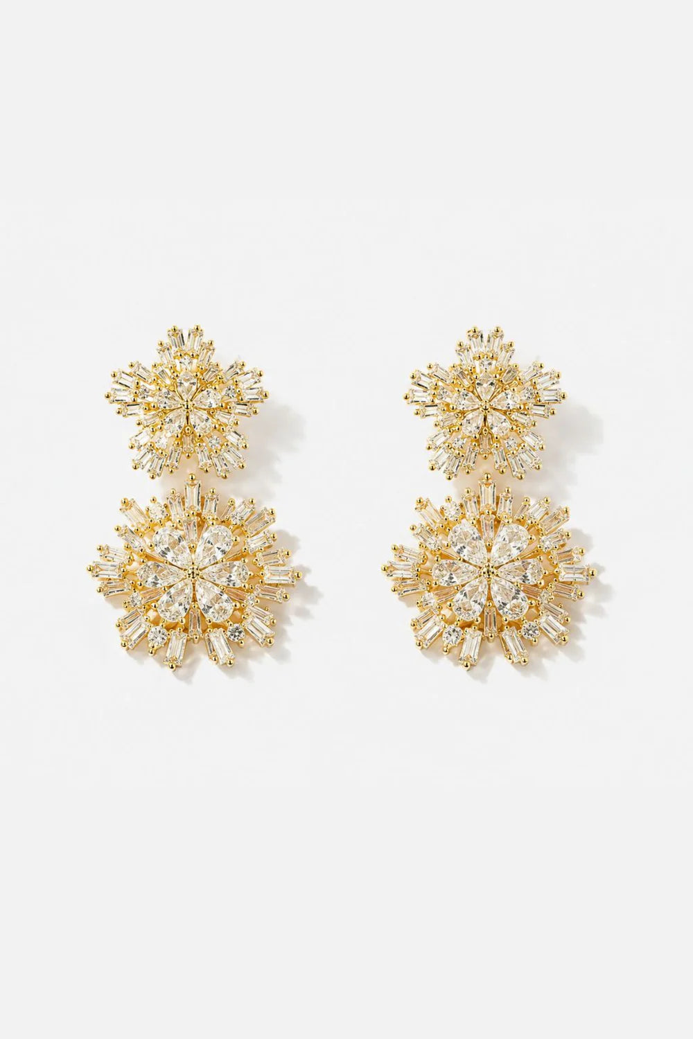 Gold snowflake earrings on a white background