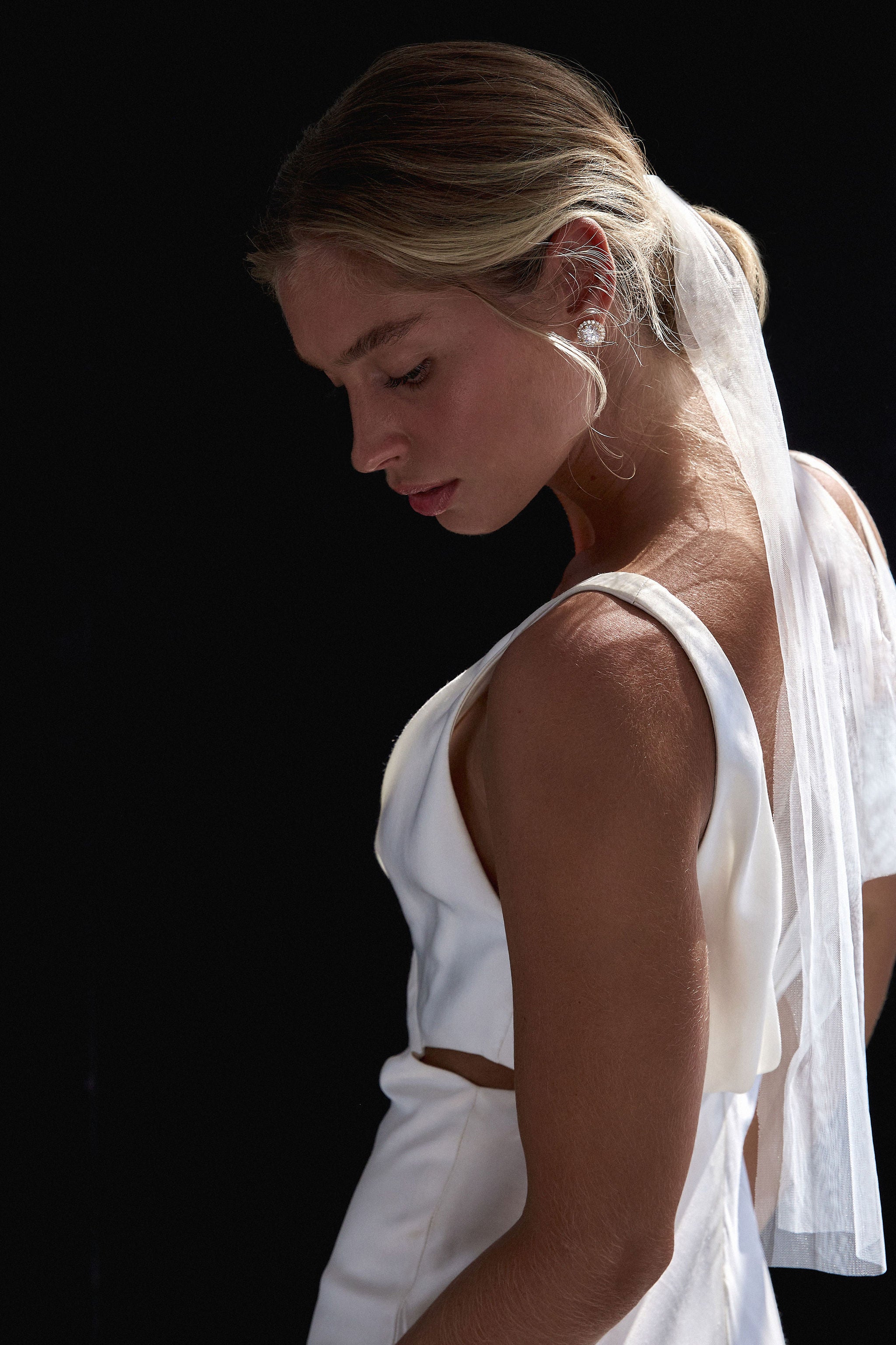 Close-up of a bride with a tulle wedding veil tie, creating a timeless, understated finish to her wedding ensemble.