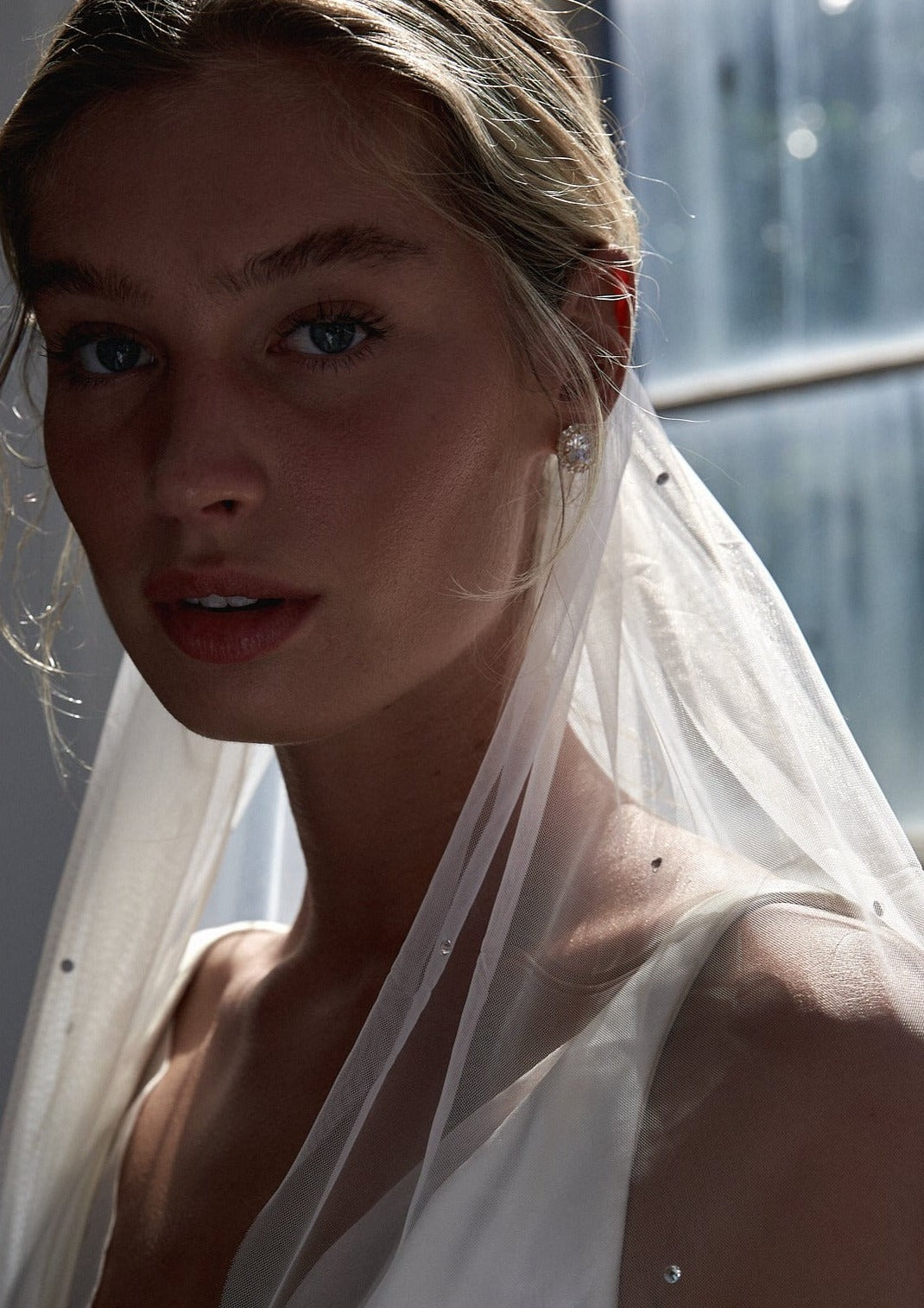 Close-up of a bride's bridal veil with delicate crystals, radiating a soft, ethereal glow.