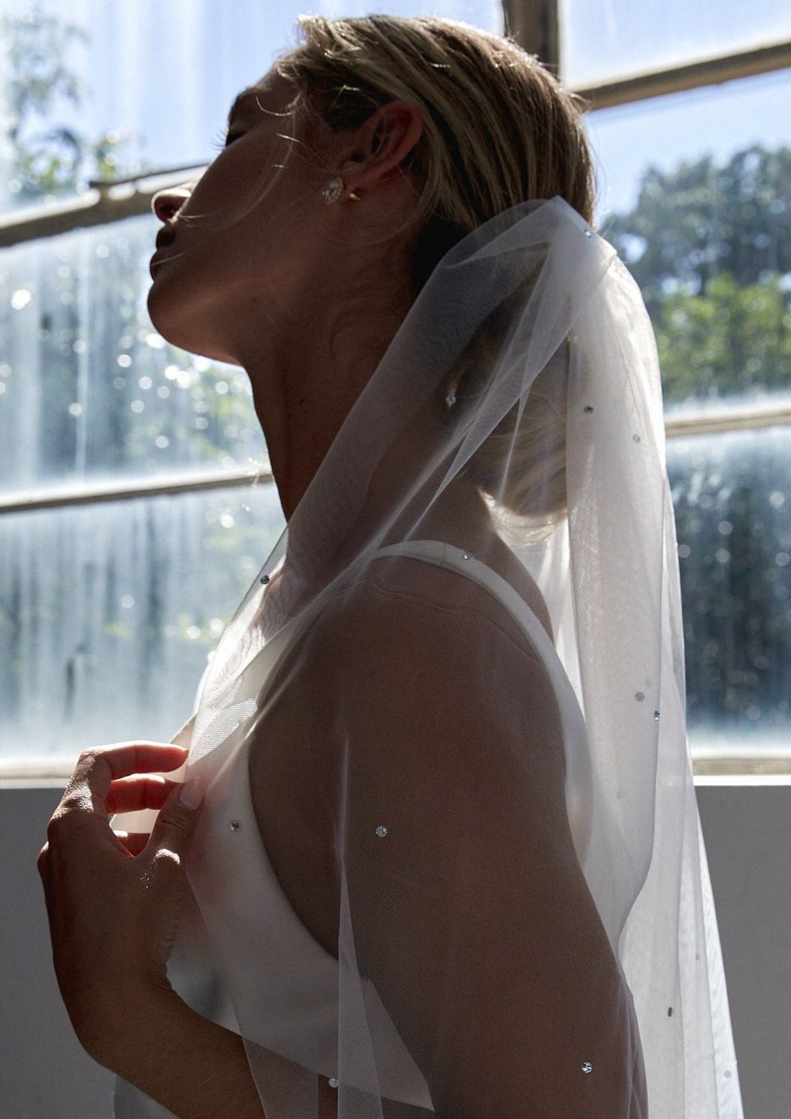Bride in a stunning crystal wedding veil, showcasing a timeless and sophisticated bridal accessory.