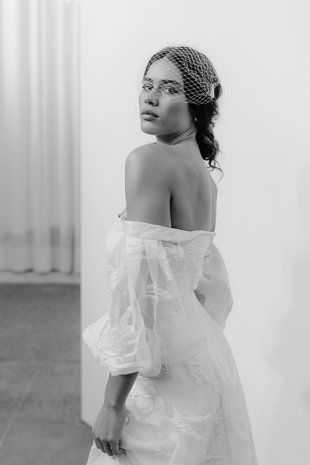 Vintage-inspired bride wearing a chic French net birdcage veil, completing her bridal look with a classic yet modern accessory.