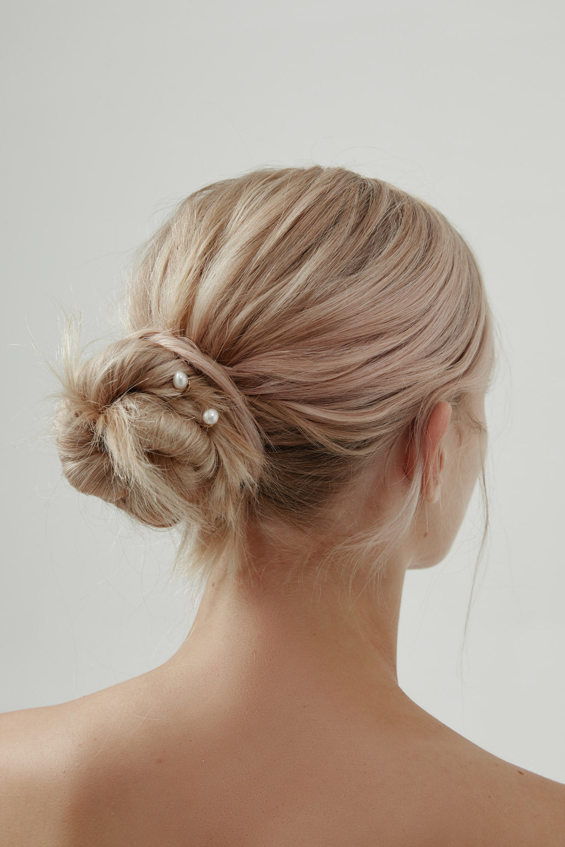 Luxurious pearl wedding hair pins in 18k gold, designed to enhance modern bridal hairstyles.