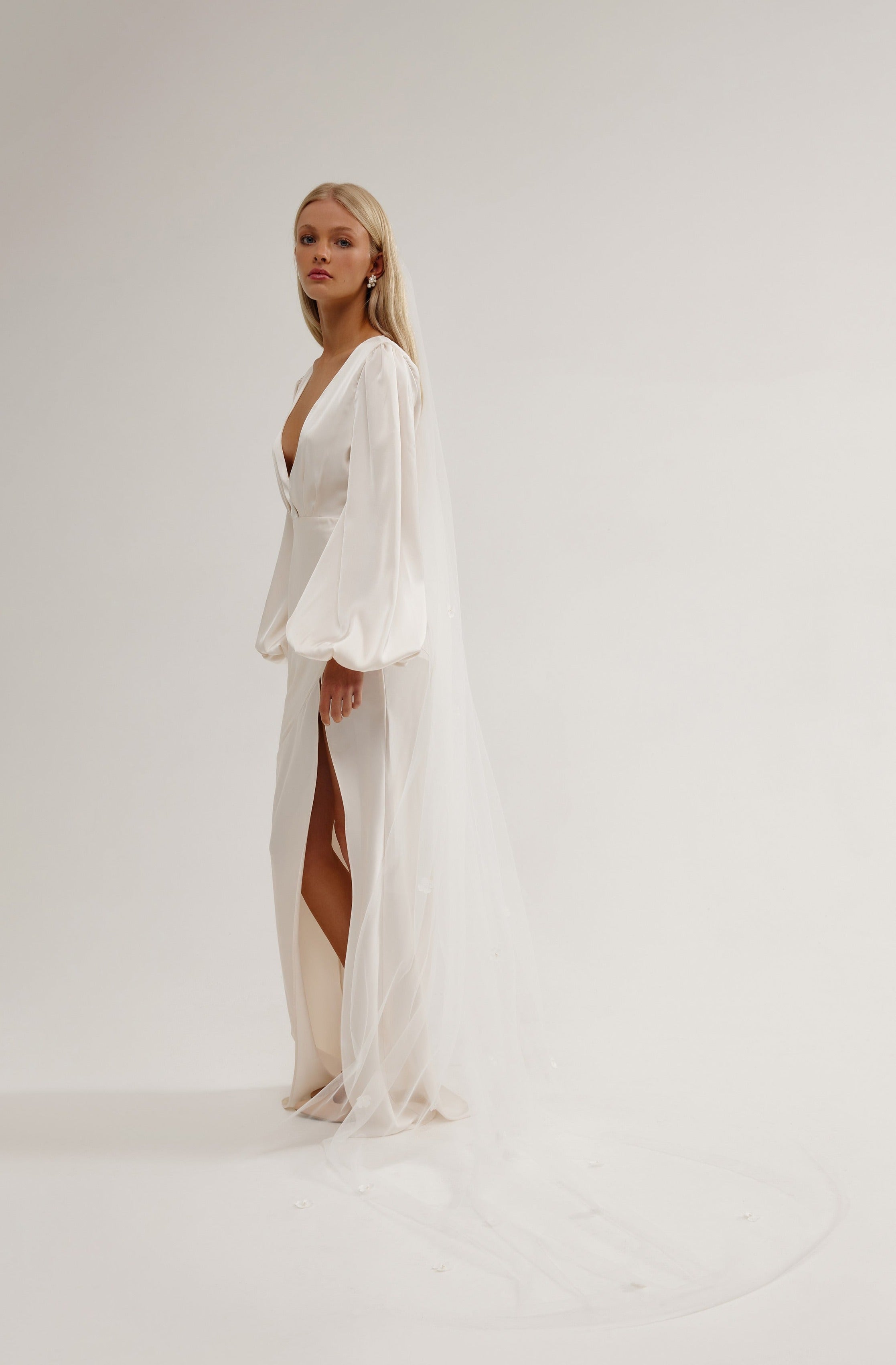 Elegant bride wearing a floral veil with three-dimensional flowers, ideal for a wedding or bridal ceremony.