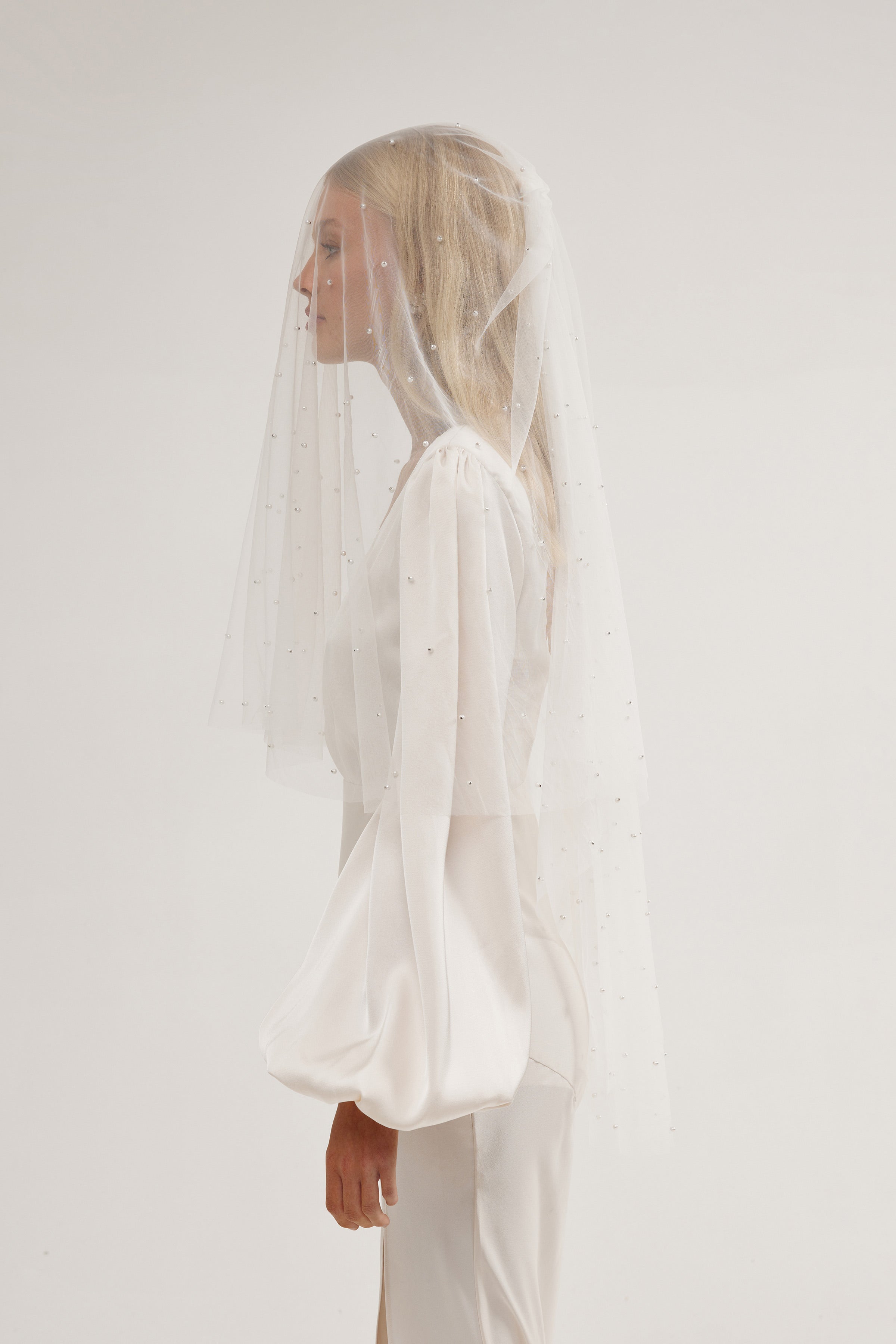 Bride wearing an ivory pearl wedding veil, perfect for long sleeve wedding dress.