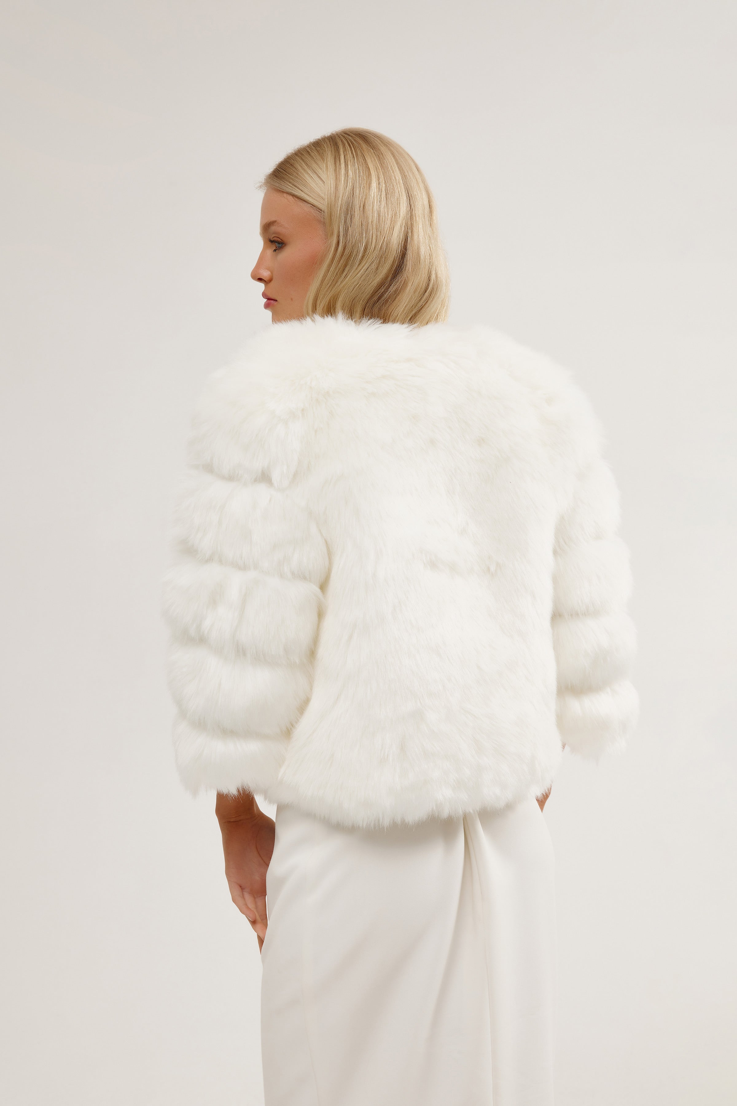 Bride in a full-length bridal jacket, perfectly paired with her wedding dress for a chic winter look.