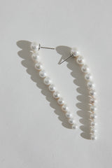 Long Gold Pearl Earrings for Bride - Silver) Modern Wedding Jewelry by Australian Jewellery Designer Amelie George Bridal on a white table in afternoon sun.