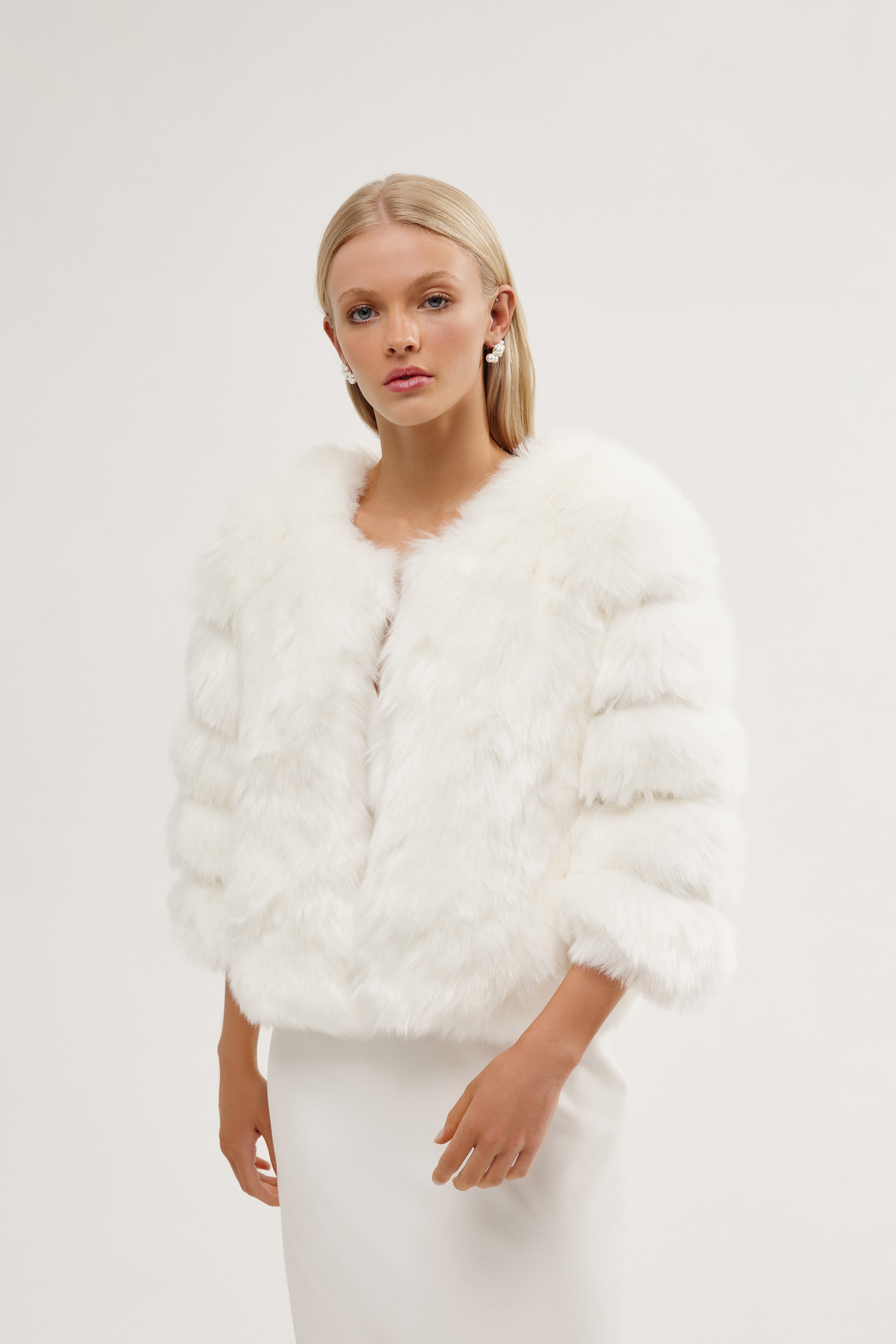 Elegant bride wearing a tiered bridal fur jacket for a luxurious winter wedding.