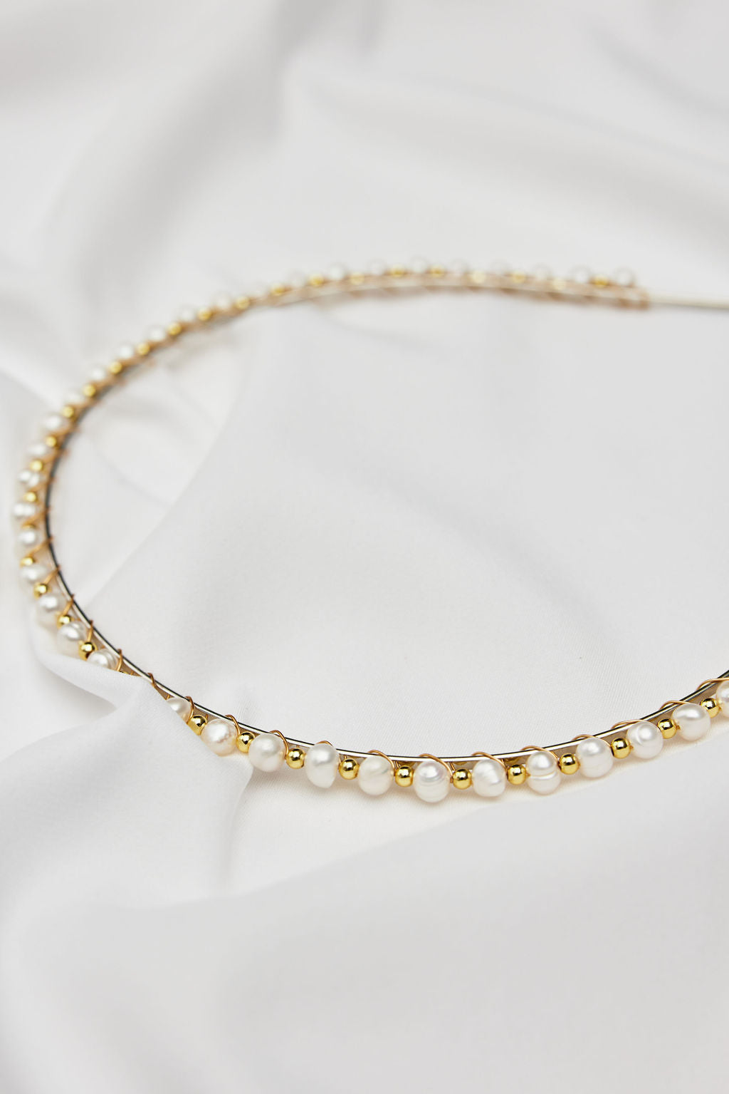 Elegant minimal pearl bridal headband with gold finish, perfect wedding hair accessory for a modern or classic bride.
