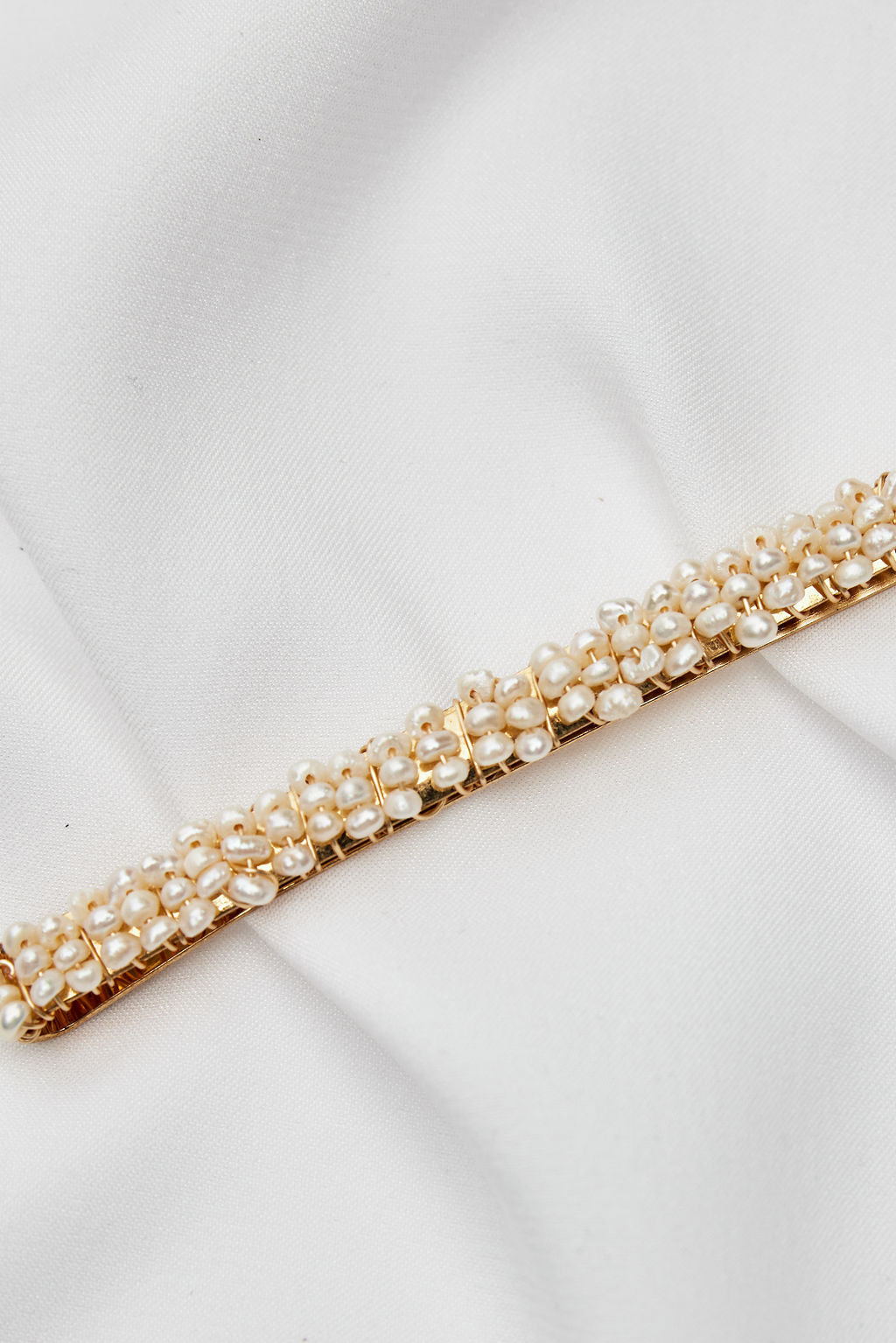 Elegant gold bridal headpiece with pearls, an ideal bridal hairpiece for a chic and romantic wedding hairstyle.