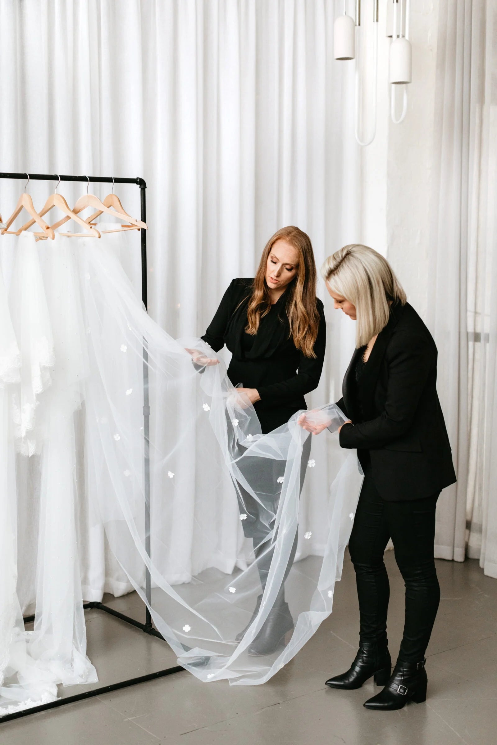Alison and sarah inspecting flower wedding veil.