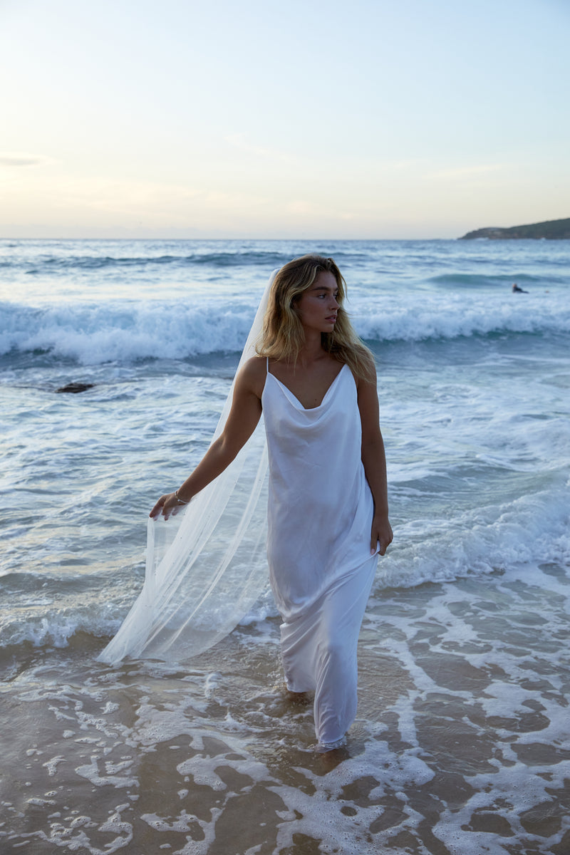 Bridal veil worn by a natural beachy bride coming out of the ocean.