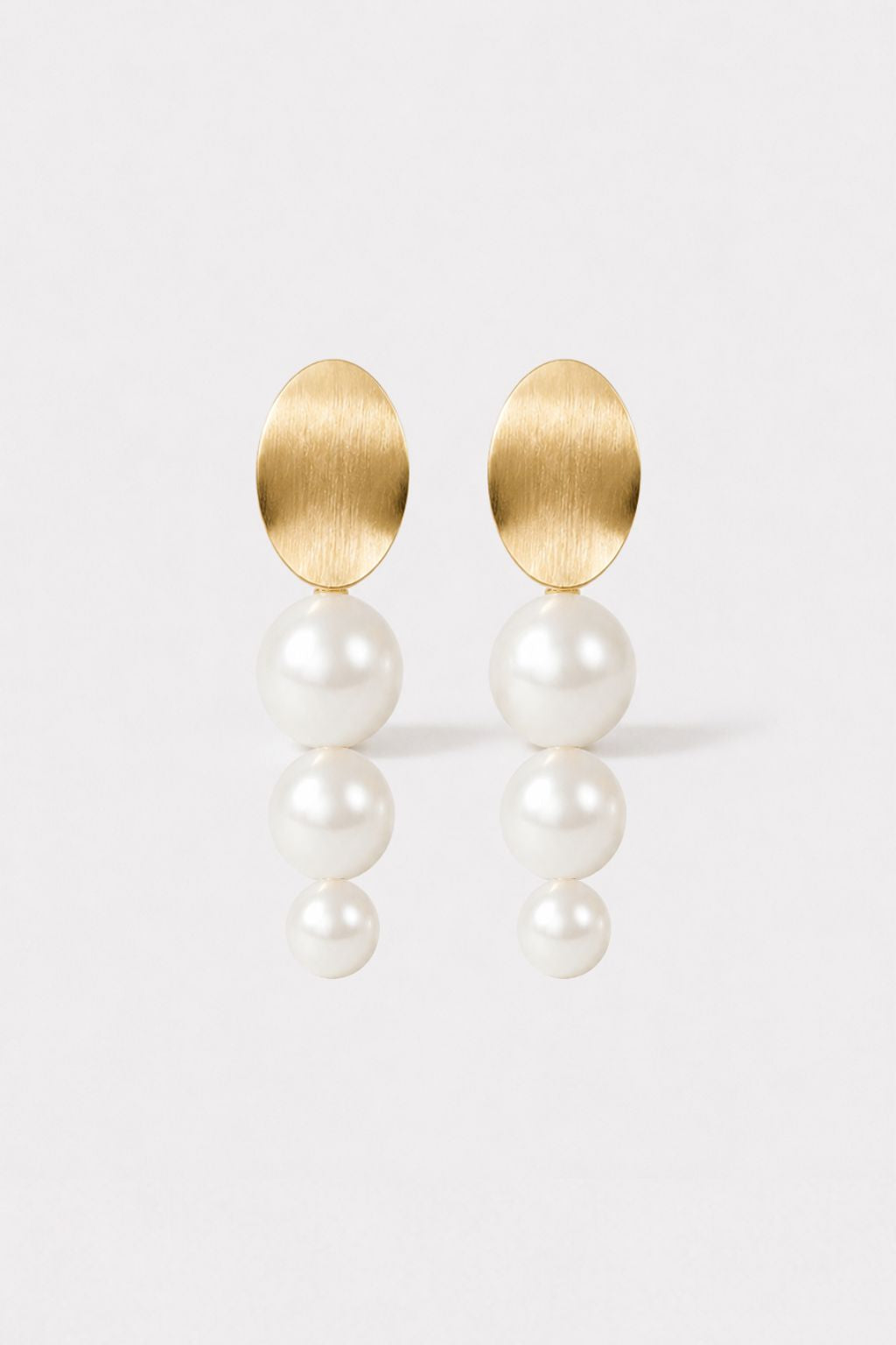 Gold and pearl wedding earrings on a light background