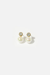 Chic Pearl Wedding Earrings on a white table in the sun - Delicate Gold Crystal Accents for Bride's Elegant and Glamorous Look