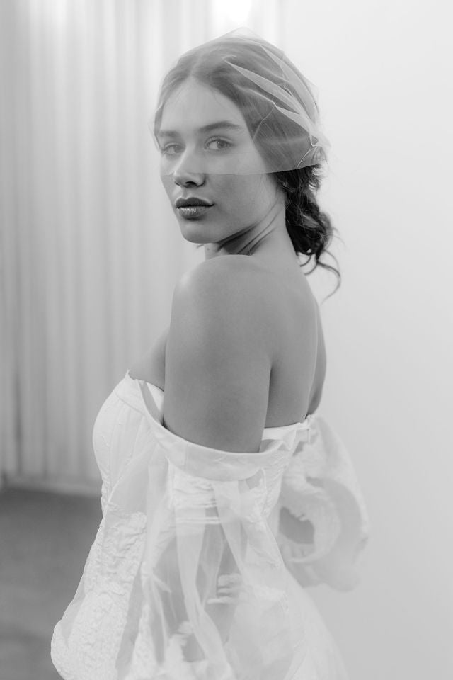 Elegant bride wearing a modern birdcage veil, showcasing a perfect blend of vintage and contemporary bridal style