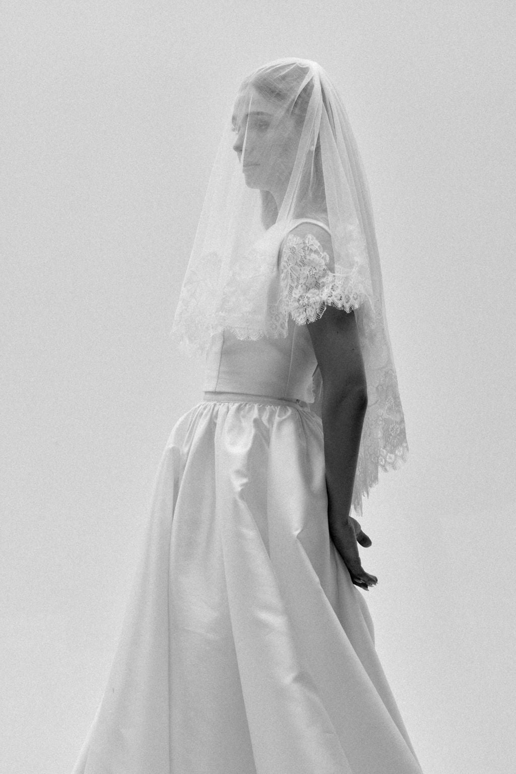 Bride wearing a two-tier lace wedding veil with blusher, showcasing delicate bridal lace details.