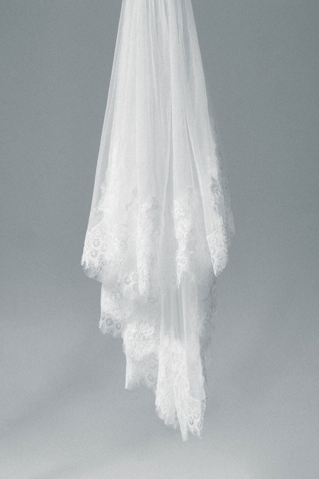 Elegant bride in a handcrafted lace bridal veil, featuring a soft and lightweight lace edge veil with blusher.