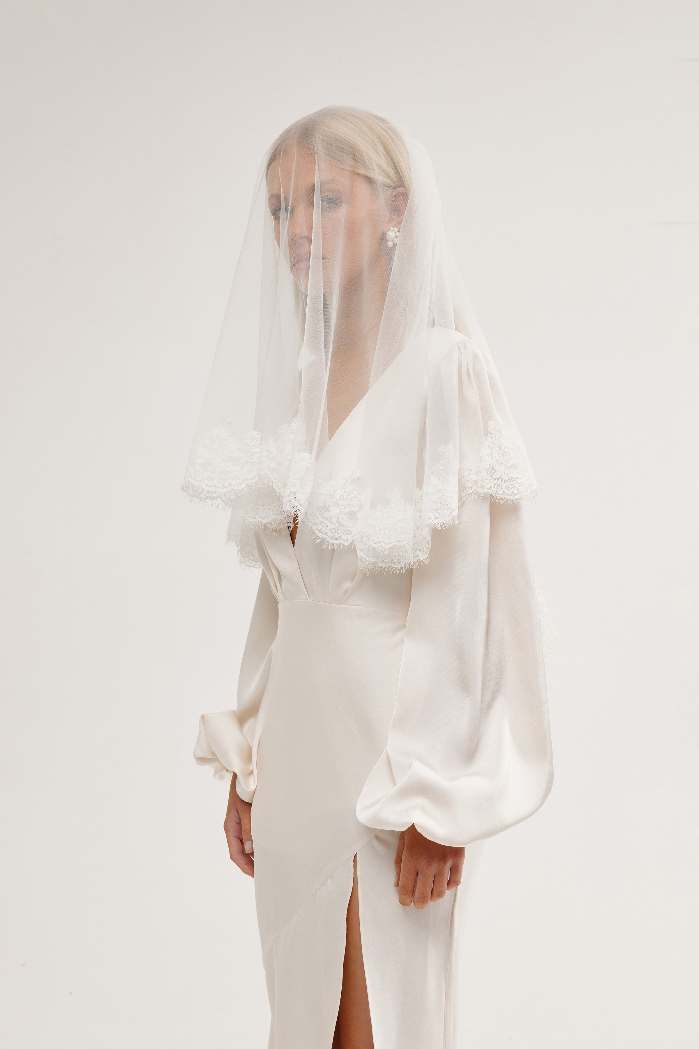 Bride in a two-tier handcrafted lace wedding veil, featuring a lightweight and delicate blusher.