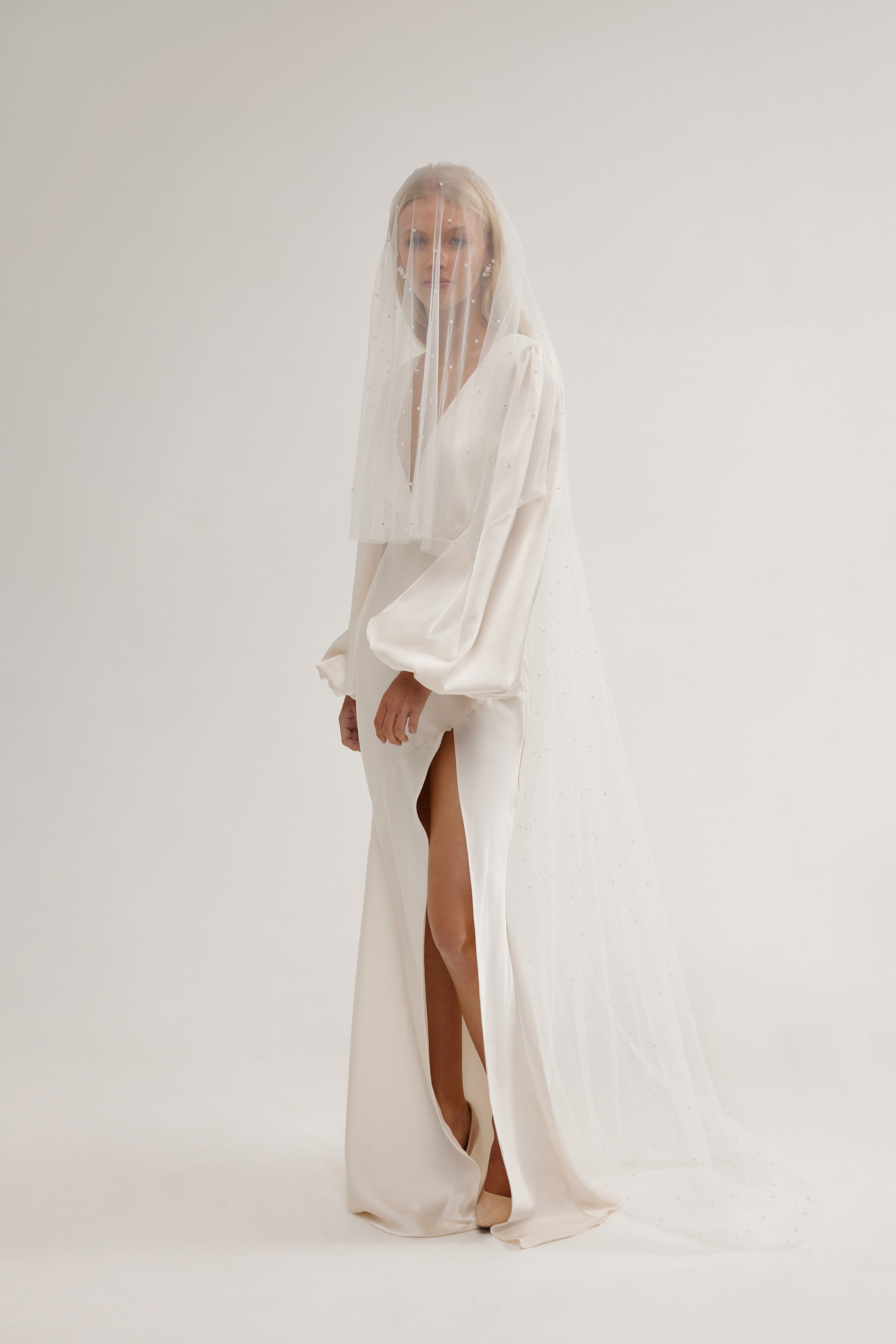 Elegant long bridal veil with pearls, capturing the ethereal beauty and soft shimmer.