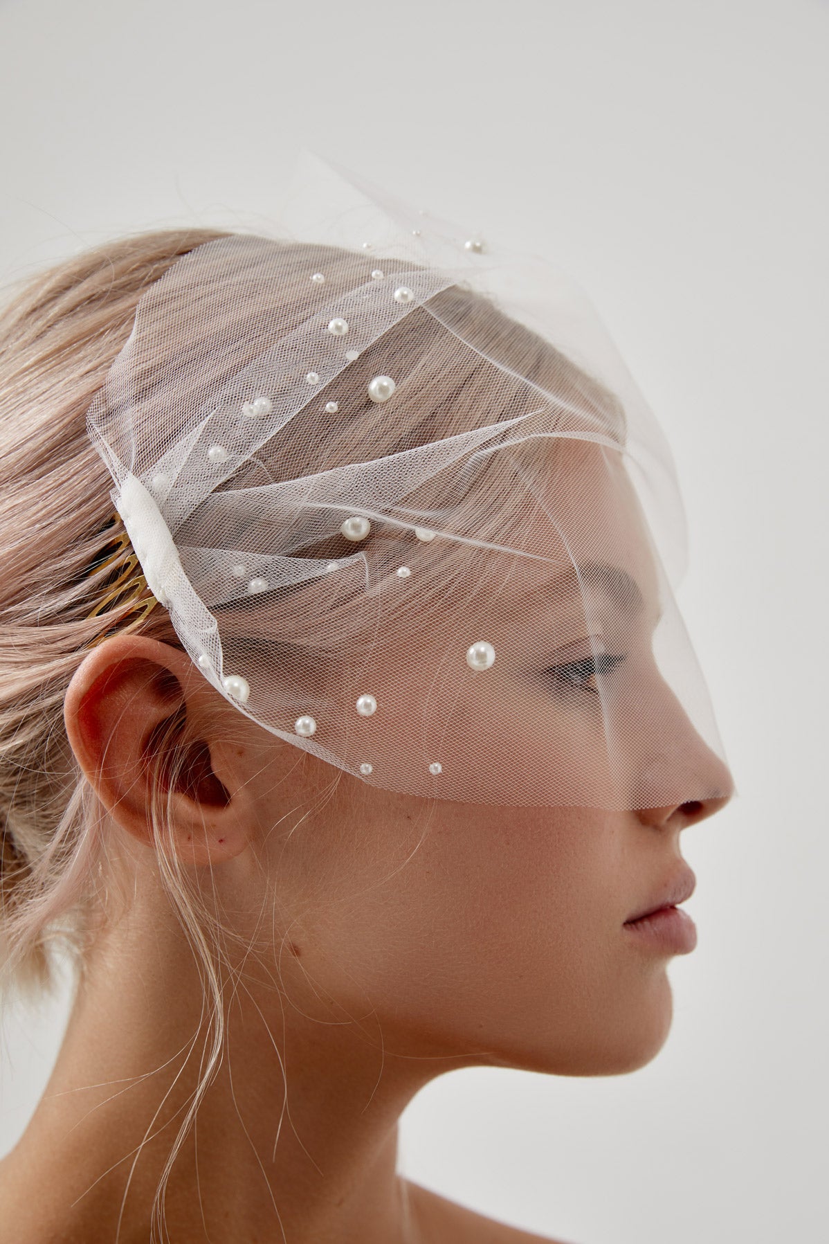 Bridal look featuring a vintage-inspired Pearl Birdcage Wedding Veil, perfect for a bride seeking a unique and timeless wedding accessory.