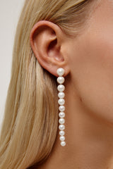 MinimClose image of wedding pearl chain earrings on a bride with straight wedding hair that's styled out.