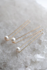 3 natural freshwater pearl hairpins on 18k gold hairstylist pins are sitting on a beautiful white crystal