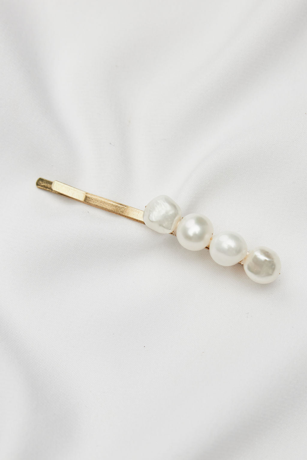 Elegant gold bridal headpiece with pearls, paired with a delicate bridal veil for a timeless wedding hair accessory.