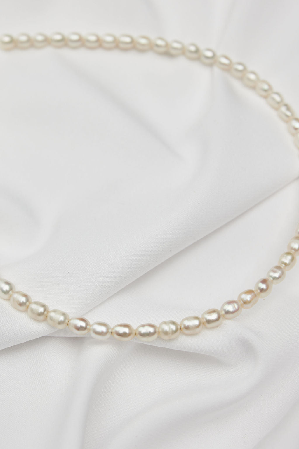 A stunning pearl bridal headband with veil, ideal for a timeless and sophisticated bridal look.
