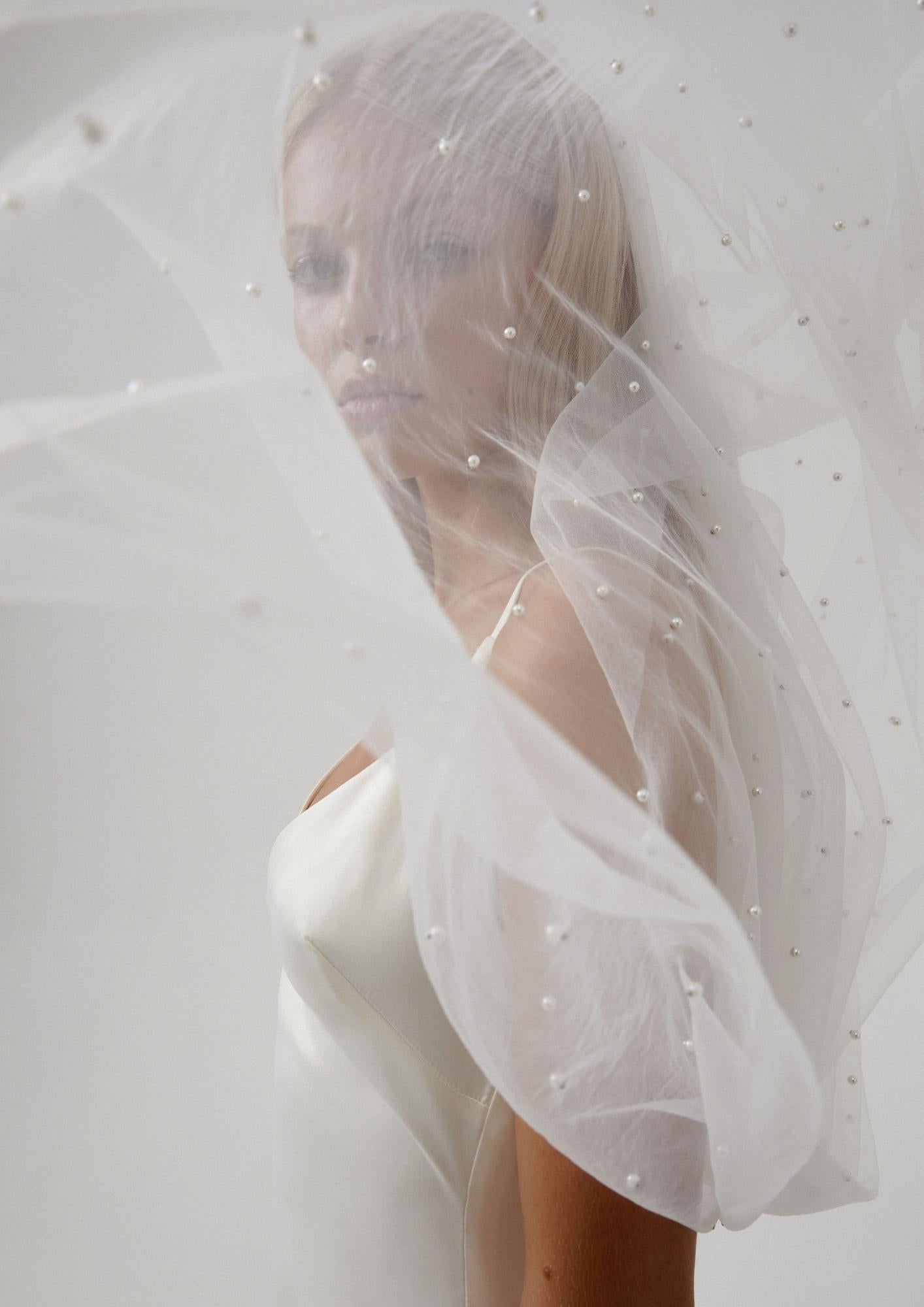 Bride wearing a pearl veil with delicate pearls, showcasing a modern bridal look.