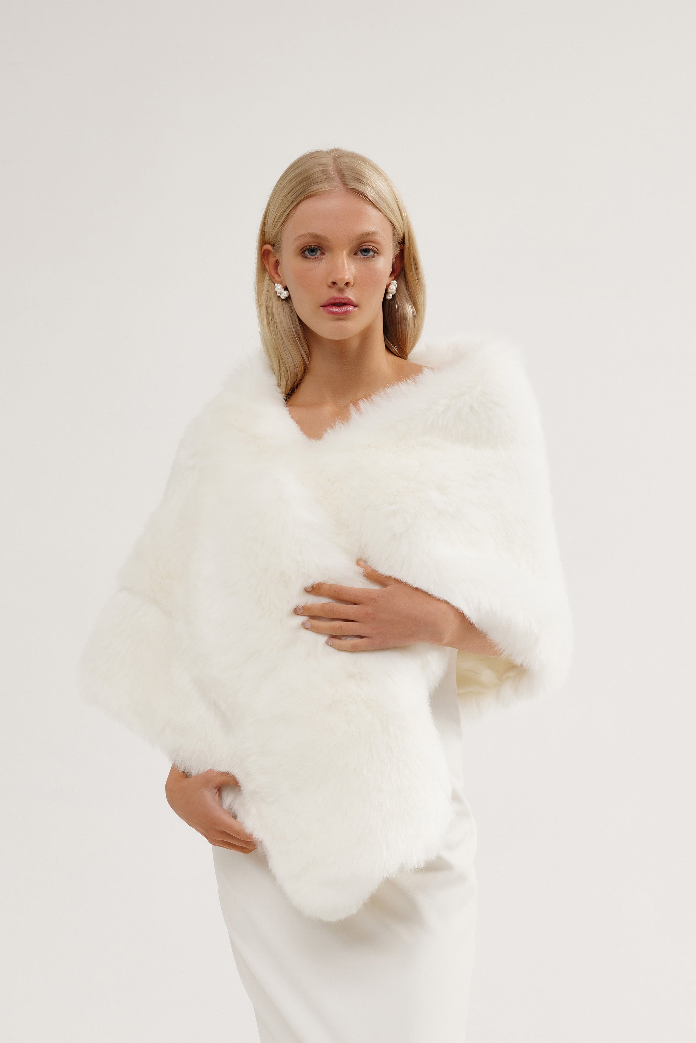 Bride wearing a large vegan fur wedding shawl over her gown at a winter wedding