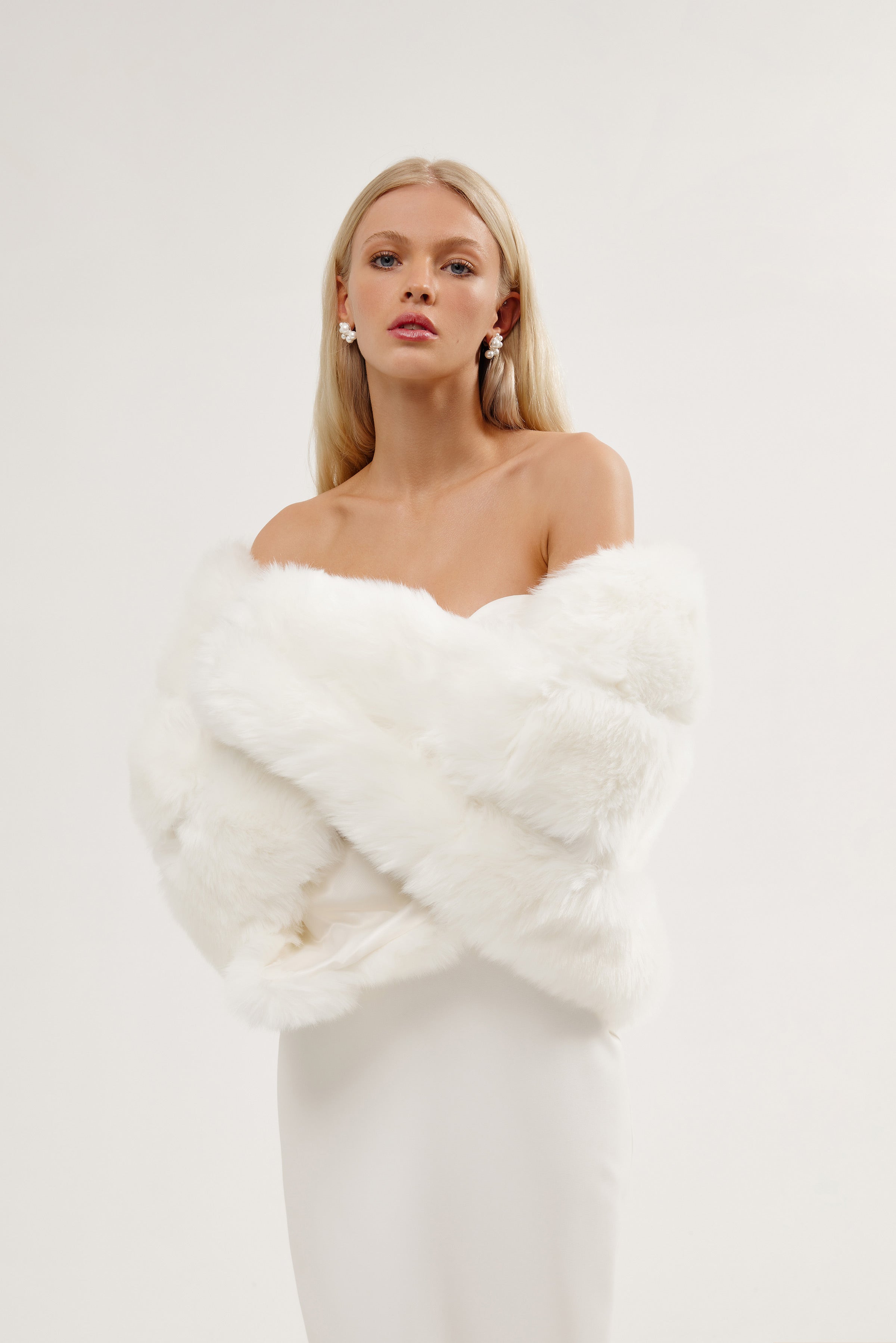Bride wearing a soft faux fur tiered wedding shawl over her gown during a winter wedding