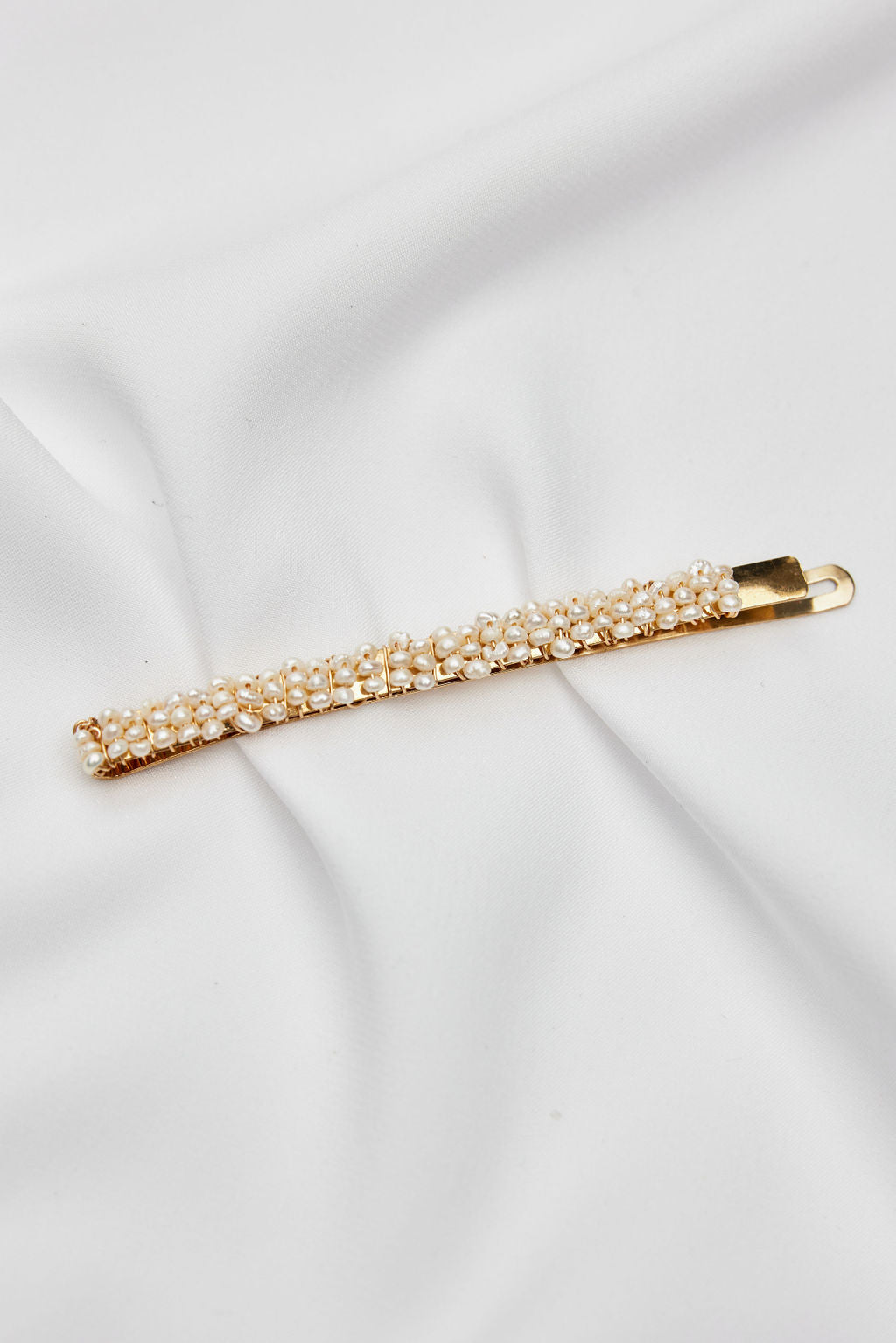 A delicate gold bridal headpiece featuring luminous pearls, perfect wedding hair accessory for a minimalist bridal look.