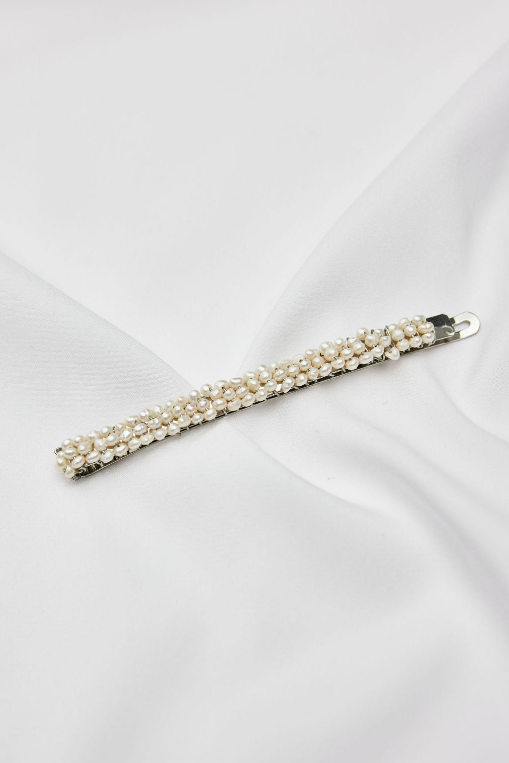 Elegant silver bridal headpiece featuring luminous pearls, perfect for minimalist bridal looks and refined wedding hair accessories.