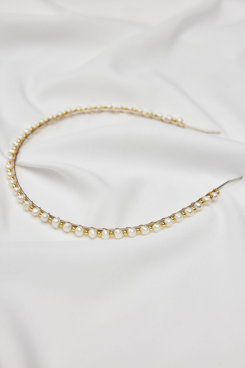 Elegant pearl bridal headband with a gold finish, perfectly paired with a Prea James wedding dress for a sophisticated bridal look.