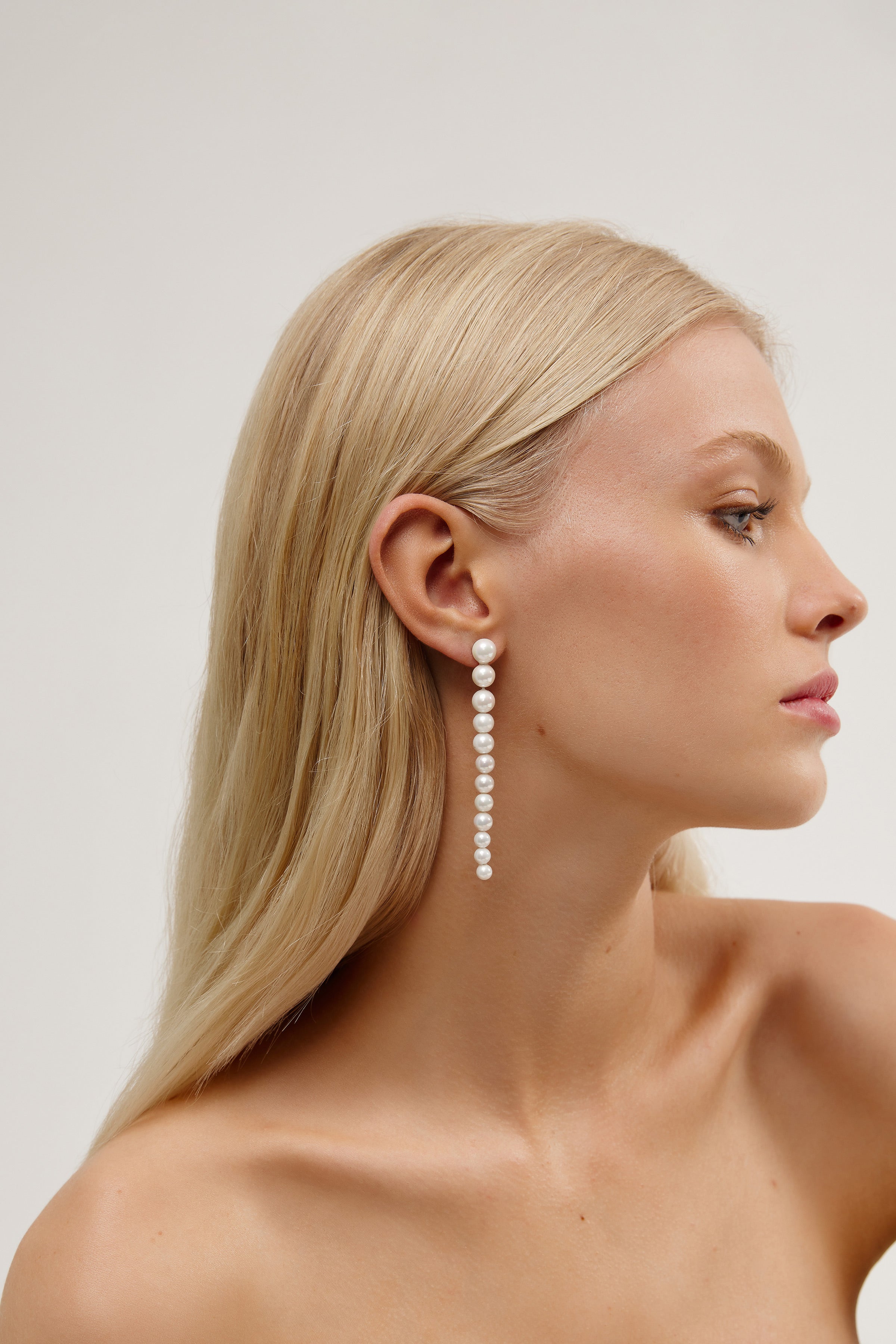 OLYMPIA silver pearl dangle earrings, a contemporary bridal jewelry piece with graceful pearls dangling from sleek silver, offering a modern elegance.