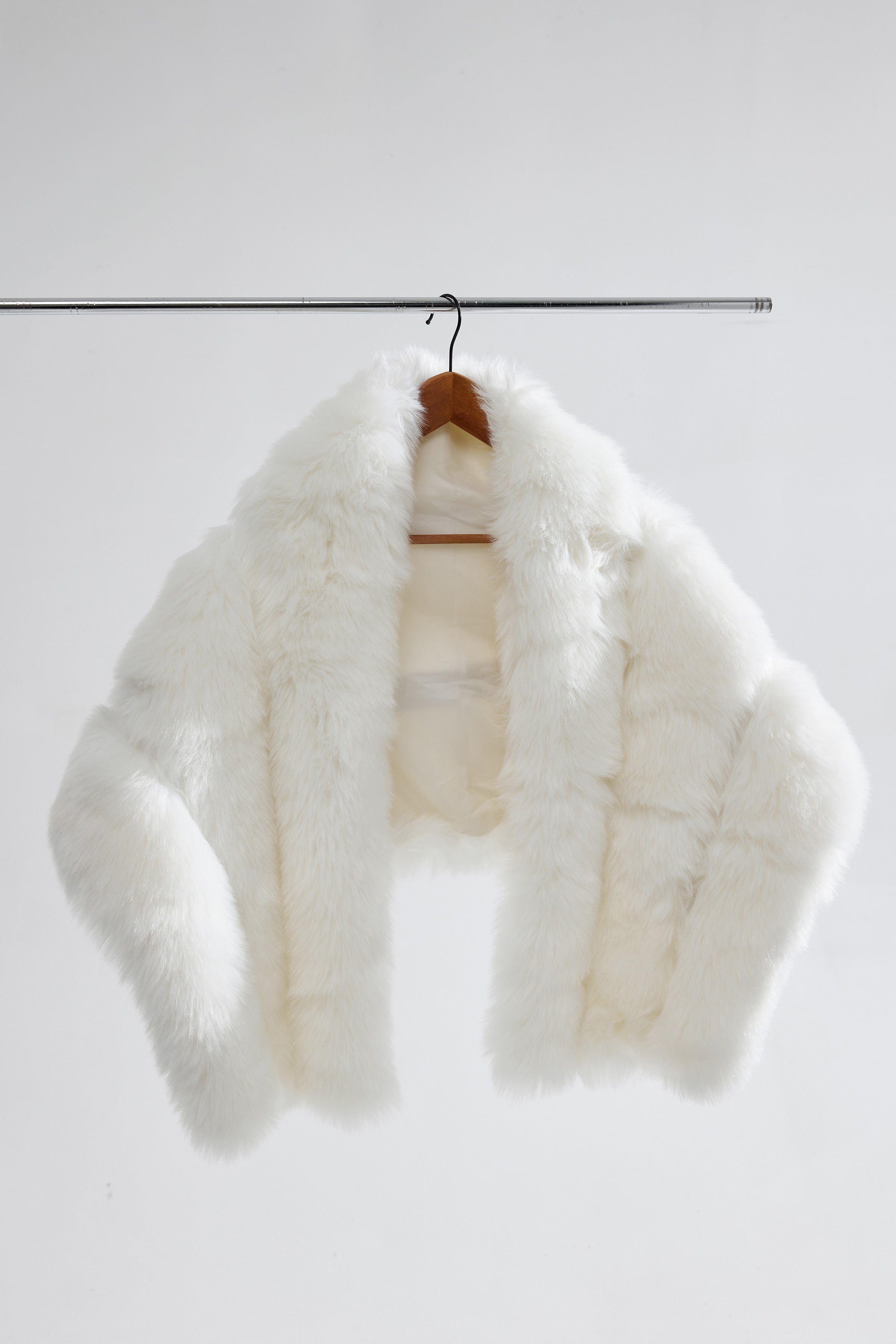 Detailed shot of the bridal faux fur shawl hanging, showing tiered texture and soft fabric